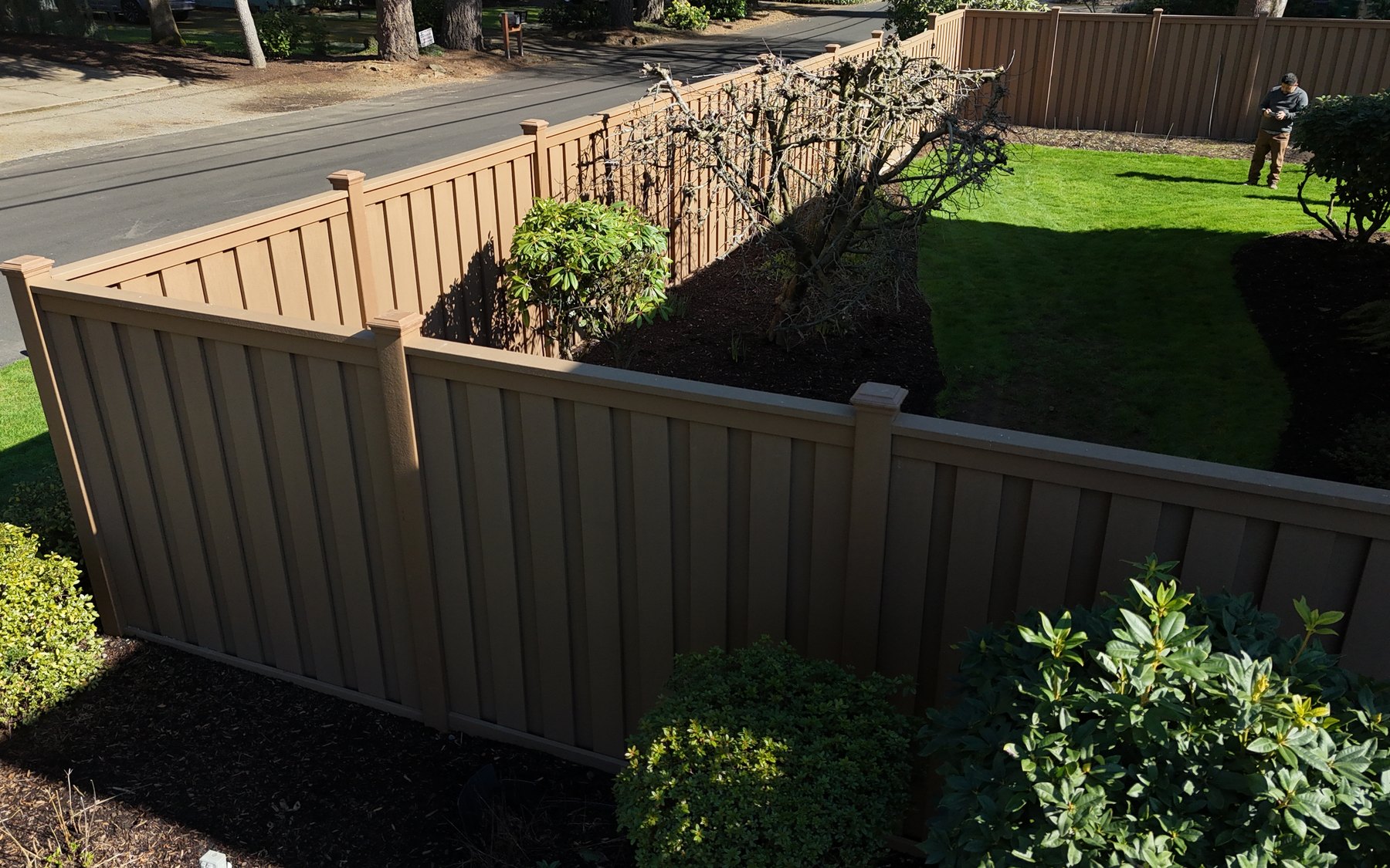 Aerial view of a composite privacy fence turning the corner of a front yard